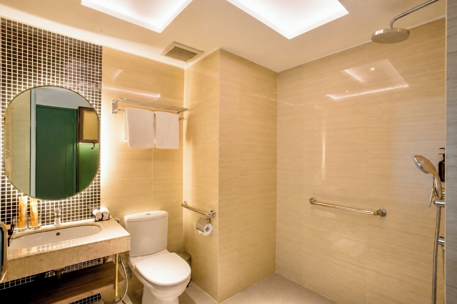Une salle de bain moderne équipée de toilettes, d’un lavabo, d’un miroir et d’une douche.