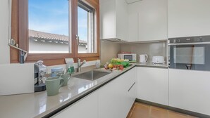 A modern kitchen with a sink, countertop, and a window. - Casa Di Bea - Lugano 1BR With Terrace & Parking (Lugano)