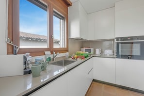 Eine moderne Küche mit Spüle, Arbeitsplatte und einem Fenster.