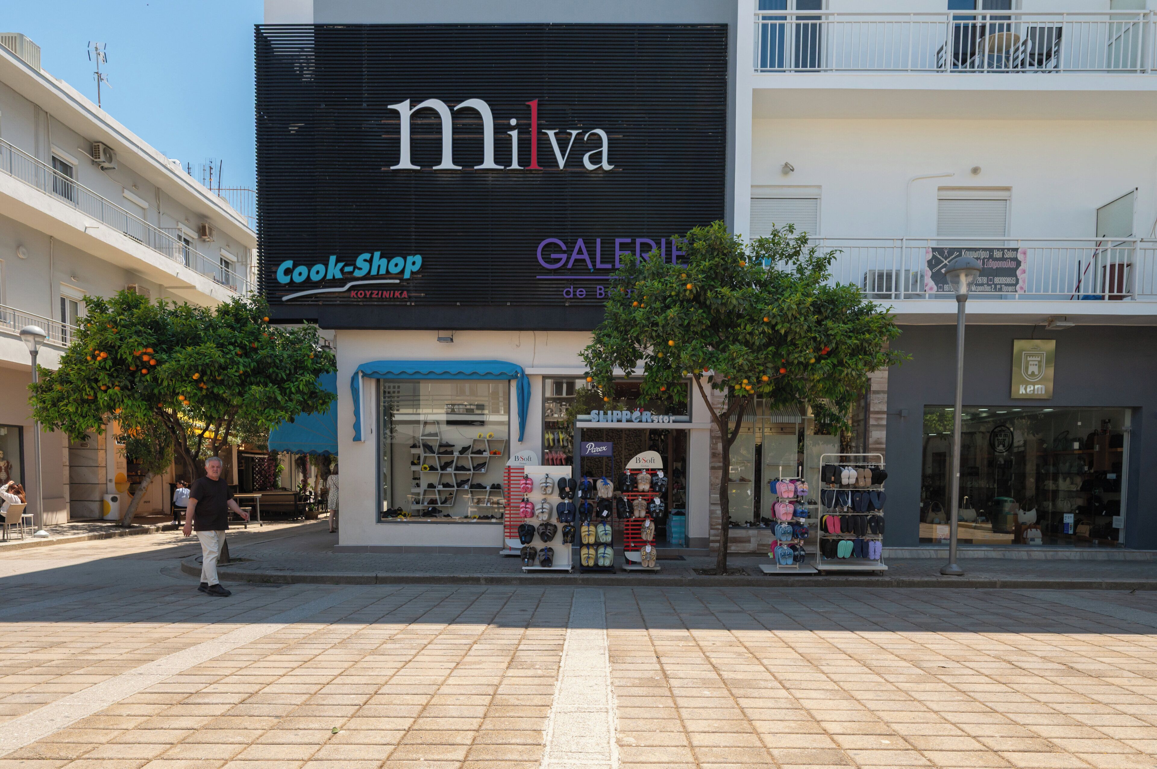 A storefront with a large sign for 'Milva' and 'Cook-Shop.'