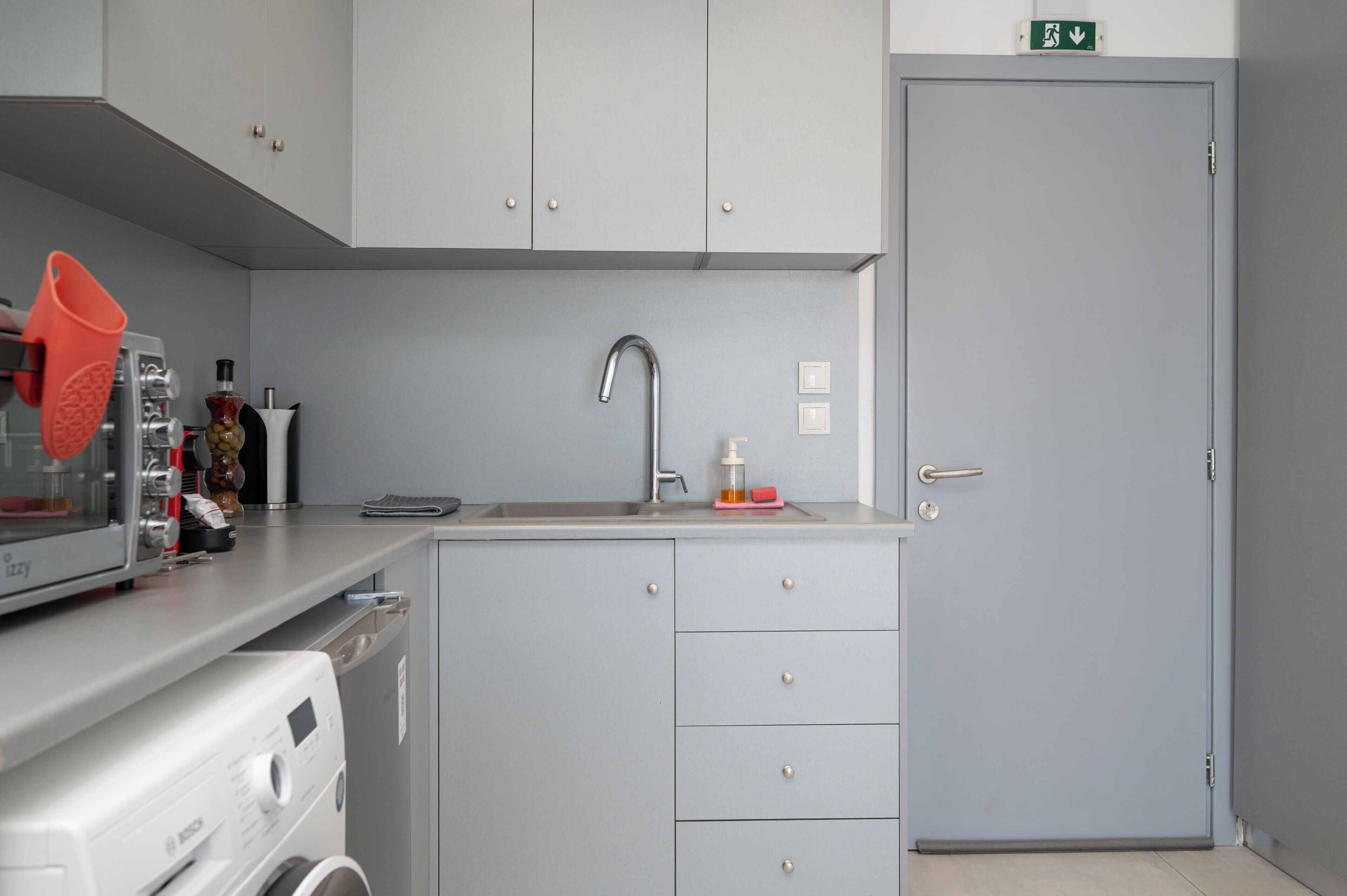 A compact kitchen with a sink, cabinets, and a microwave.