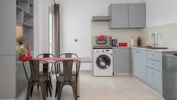 Een compacte keuken met een wasmachine, een inbouwoven en een spoelbak.
