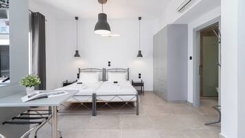 Un dormitorio moderno con una cama, mesitas de noche, un escritorio y una planta en maceta.