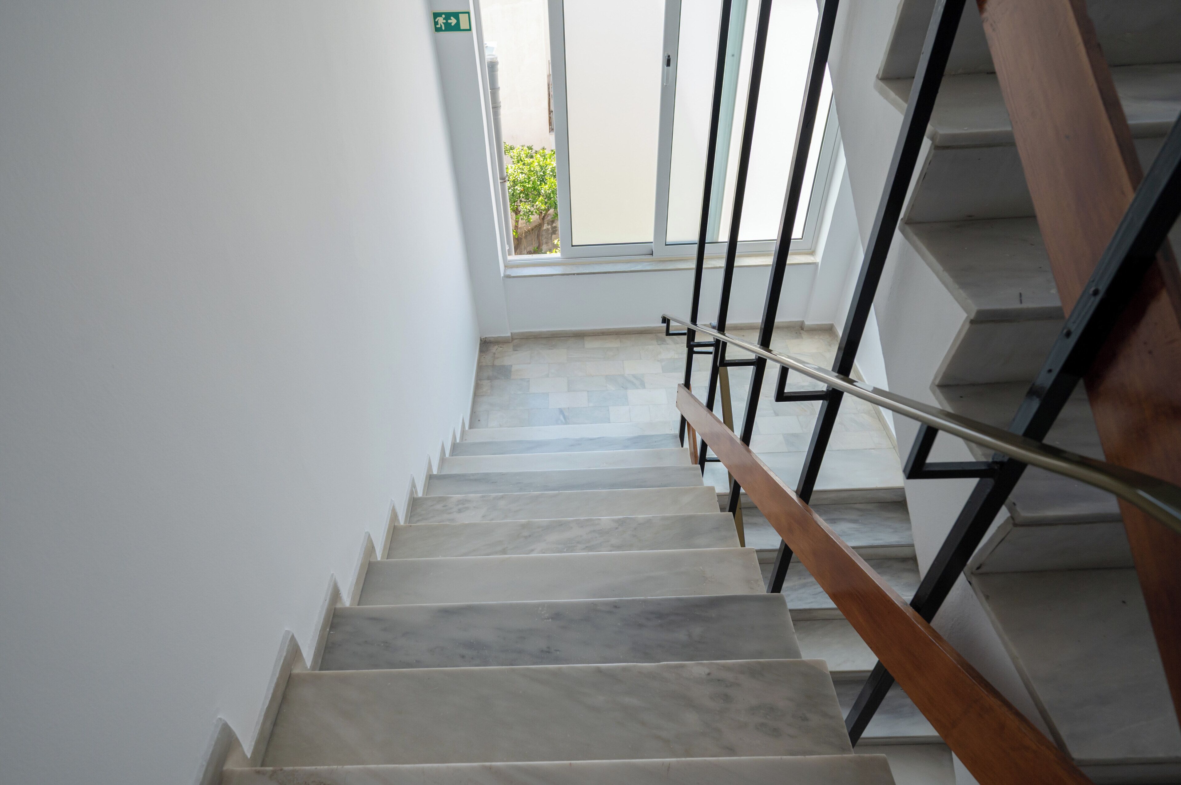 A staircase with a metal handrail and wooden steps leading to an upper floor.