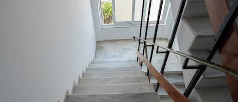 A staircase with a metal handrail and wooden steps leading to an upper floor.