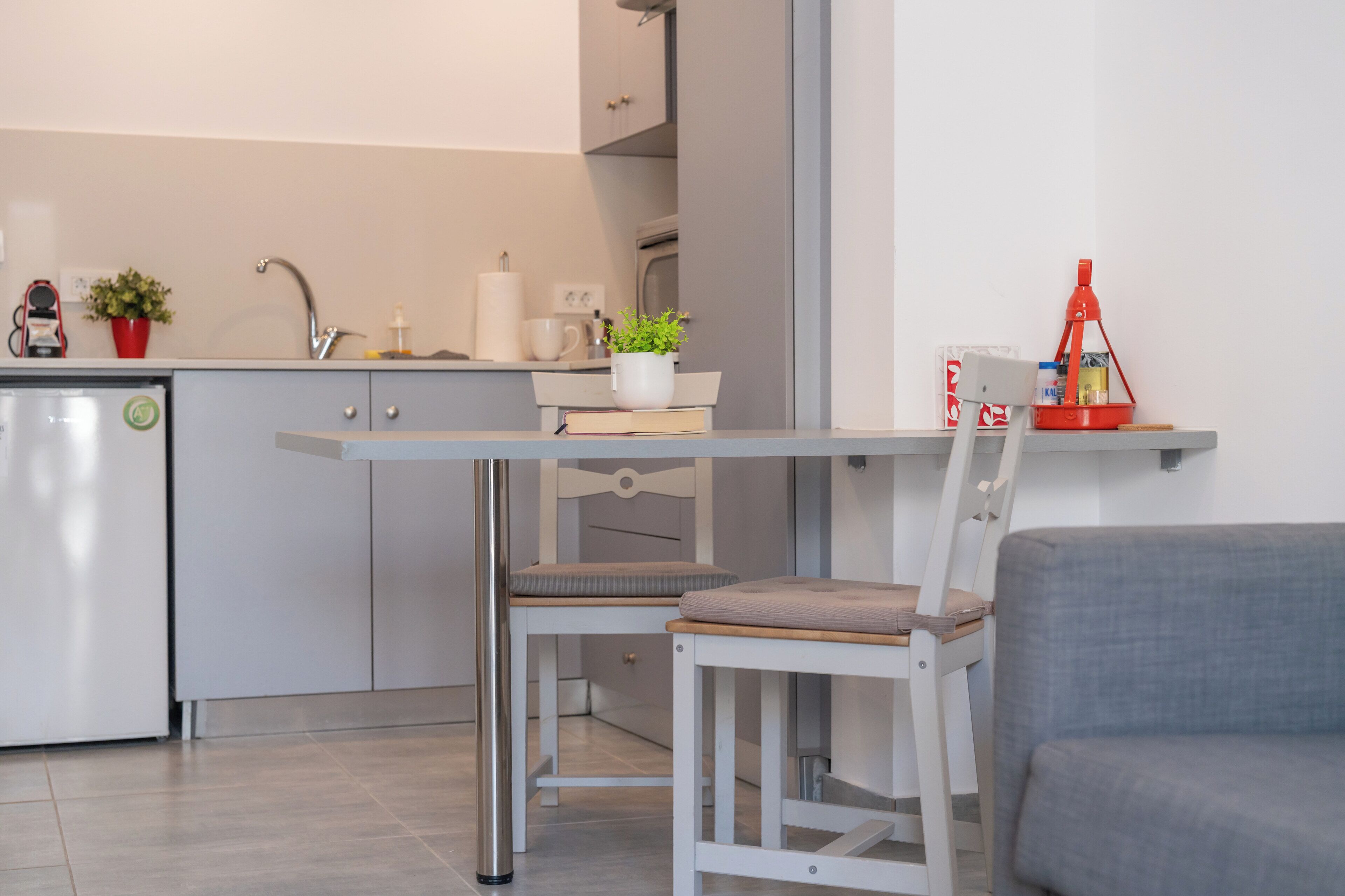 Une cuisine moderne avec un coin repas comprenant une table, des chaises et un réfrigérateur.