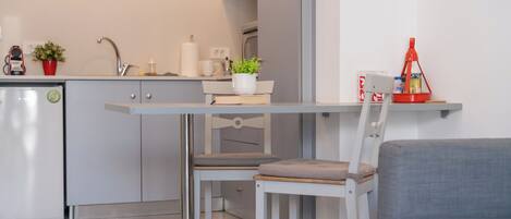 Une cuisine moderne avec un coin repas comprenant une table, des chaises et un réfrigérateur.
