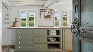 A kitchen with a window, a sink, and a green cabinet. - Peace and nature in a historic holiday home (Højer)