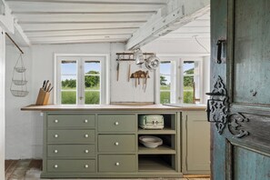 A kitchen with a window, a sink, and a green cabinet.