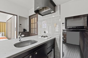 A modern bathroom with a sink, mirror, and towel rack. - Grace Nagahori 402 (Osaka)
