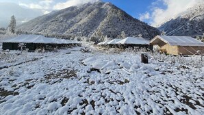 Un paysage enneigé avec des tentes et une montagne en arrière-plan.