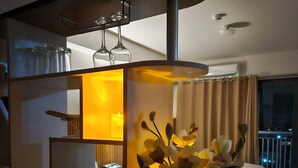 Ein modernes Wohnzimmer mit einem Glastisch, einer Blumenvase und einer Couch.