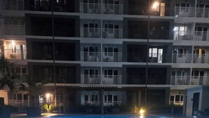 Ein Schwimmbad, umgeben von einem mehrstöckigen Gebäude mit Balkonen.
