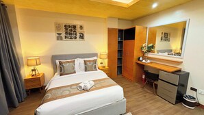 Une chambre d’hôtel avec un lit, un bureau, une armoire et un miroir.