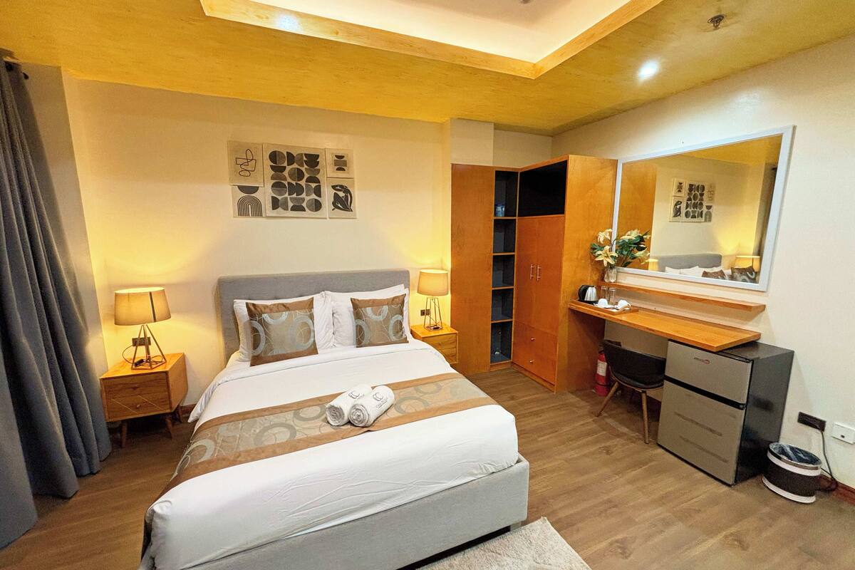 Ein Hotelzimmer mit Bett, Schreibtisch, Kleiderschrank und Spiegel.