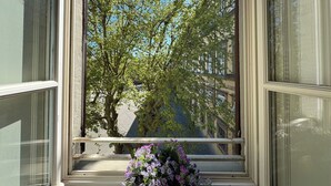 Une fenêtre donnant sur des arbres et des immeubles.
