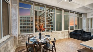 A modern interior with a dining area, large windows, and a city view. - Dual King Suites | Skyline Views | Downtown ATL (Atlanta)
