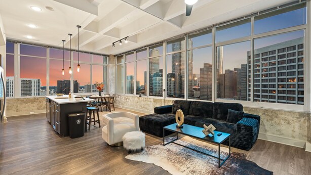 A spacious living area with a city view, a modern kitchen, and a large window. - Dual King Suites | Skyline Views | Downtown ATL (Atlanta)