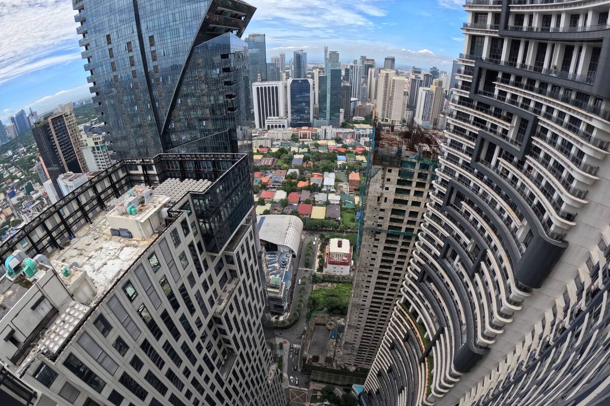 A high-rise building with a unique curved architecture, multiple floors, and a rooftop terrace.