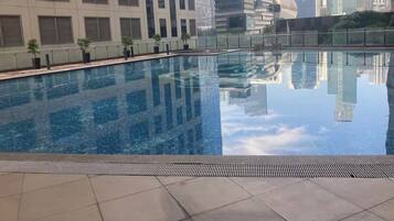 A swimming pool with a cityscape view, surrounded by buildings.