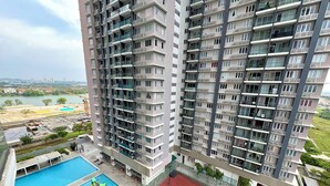 Un edificio residenziale di grandi dimensioni con numerosi balconi, una piscina e un campo da tennis.