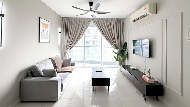 Un soggiorno moderno con un divano, un tavolino, una TV e una ventola a soffitto.