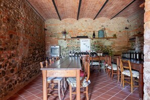 A rustic wine cellar with stone walls, wooden tables, and chairs. There are wine bottles on shelves and a sign that reads "Il Gattero". - Flat With Swimming Pool and air Conditioning (Peccioli)