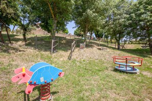 Ein Spielplatz mit einer Wippe und einem Karussell.