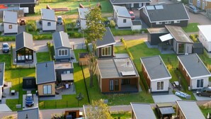 Ett bostadsområde med moderna hus, varav några har garage som är sammanbyggda med huset, och en välskött gräsmatta.