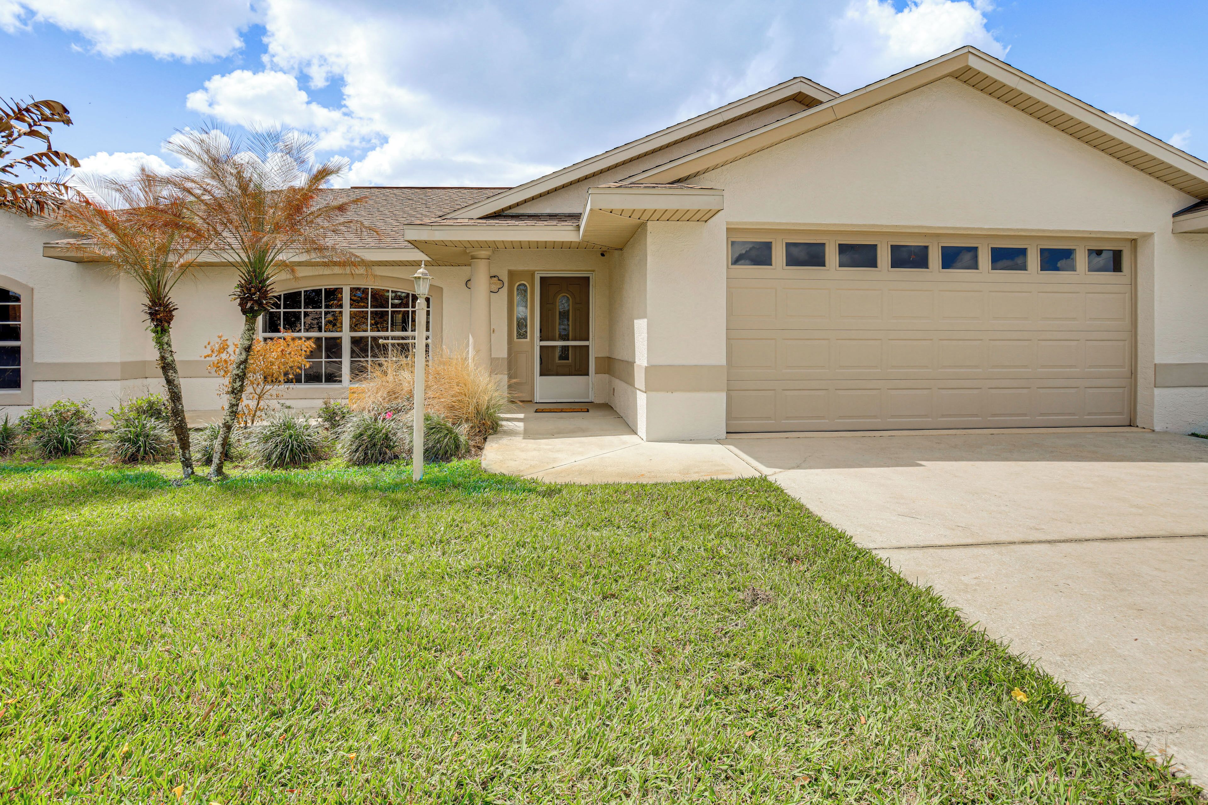 A single-story house with a garage, a front porch, and a well-maintained lawn.