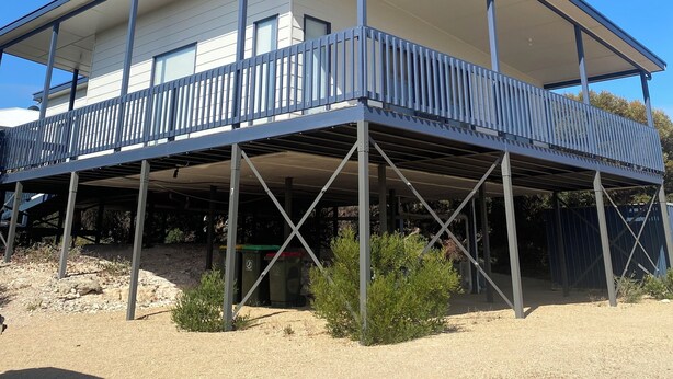 A two-story building with a balcony on the ground floor.