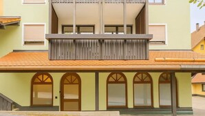 Un edificio con techo plano, un balcón con listones verticales y una serie de ventanas de arco.