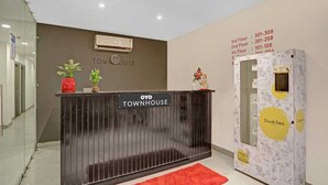 A reception desk with a sign reading "OYO TOWNHOUSE" and a wall with floor numbers and room numbers. - Townhouse Samaypur Badli Metro Station (New Delhi)