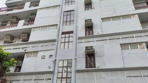 A multi-story building with air conditioning units on each floor, a central vertical structure, and a door at the bottom. - Townhouse Samaypur Badli Metro Station (New Delhi)