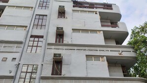 A multi-story building with a flat facade, multiple balconies, and several air conditioning units. - Townhouse Samaypur Badli Metro Station (New Delhi)