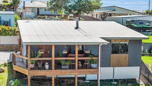 Ein modernes, zweistöckiges Haus mit Balkon, Garage und einem gepflegten Garten.