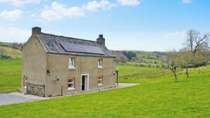 A two-story house with a sloped roof, a small front porch, and a solar panel on the roof. - 3 bedroom accommodation in Brough (Brough)