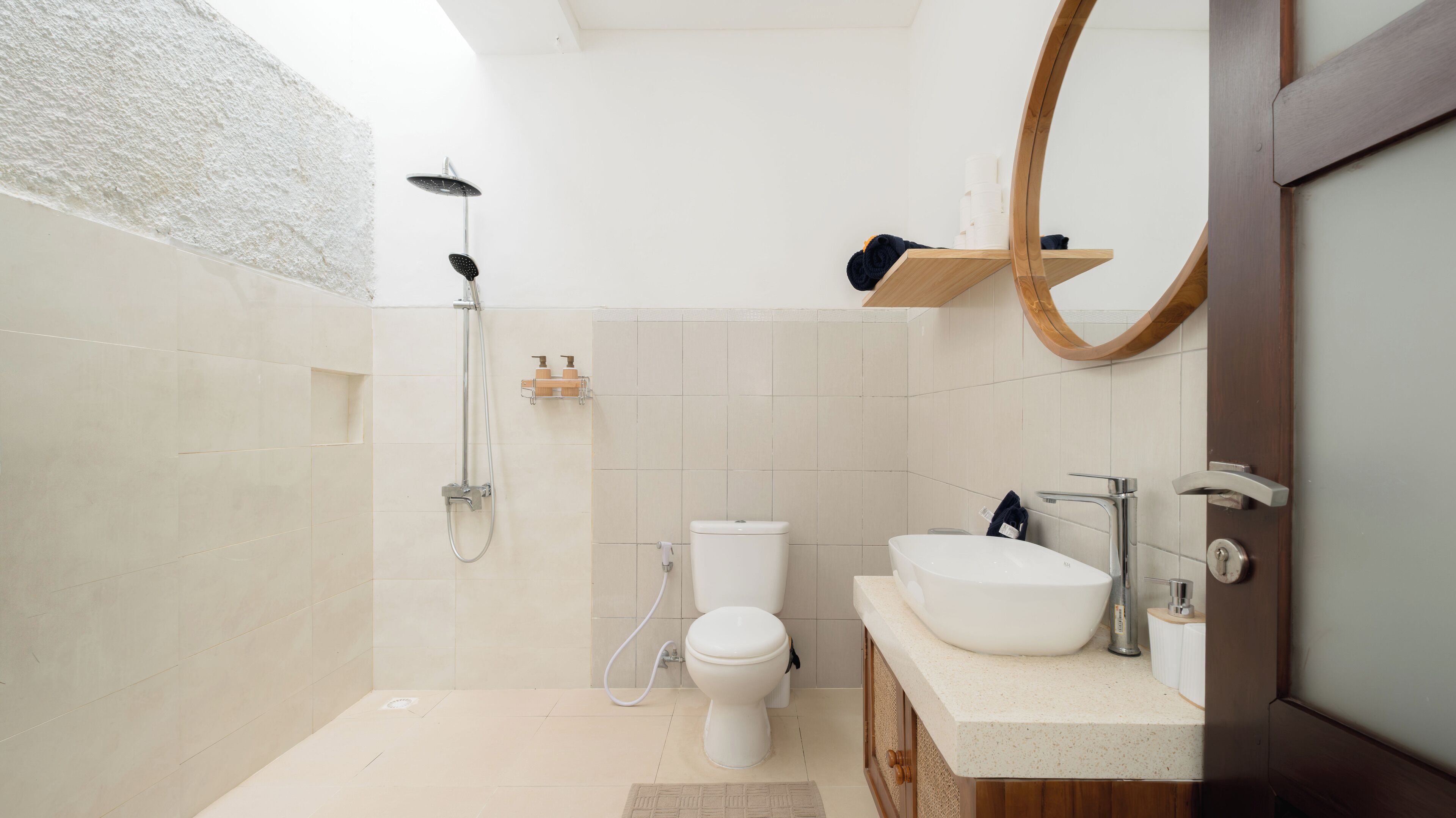 Een moderne badkamer met douche, toilet en wastafel.