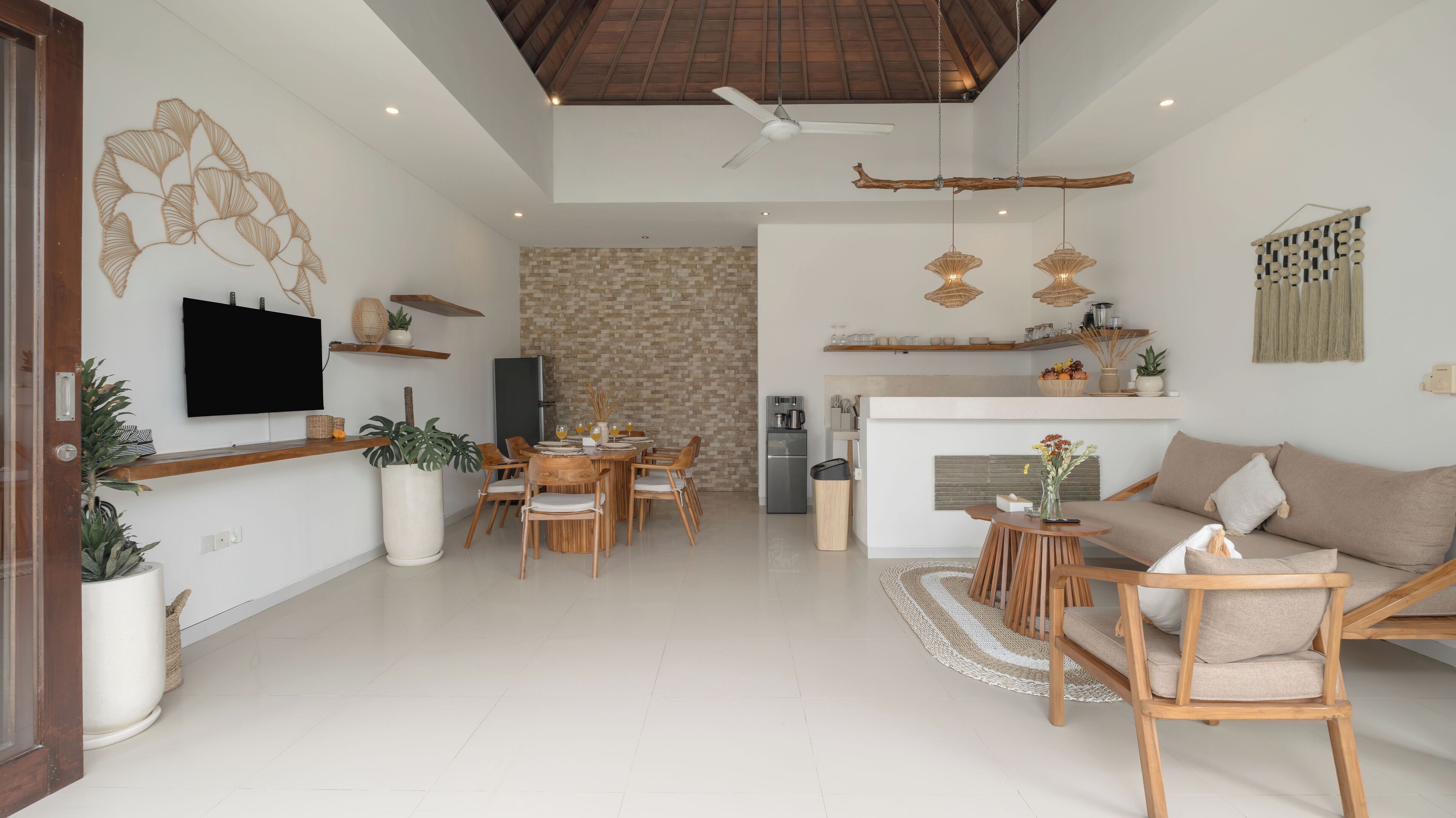 A modern living room with a sofa, dining area, and kitchen.