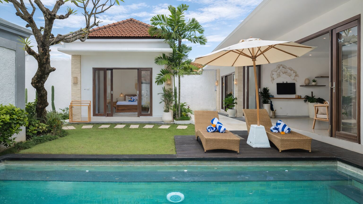 A modern villa with a swimming pool, outdoor seating, and a well-maintained garden.