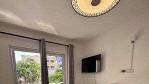 Ein modernes Wohnzimmer mit Flachbildfernseher, Esstisch und Sofa.