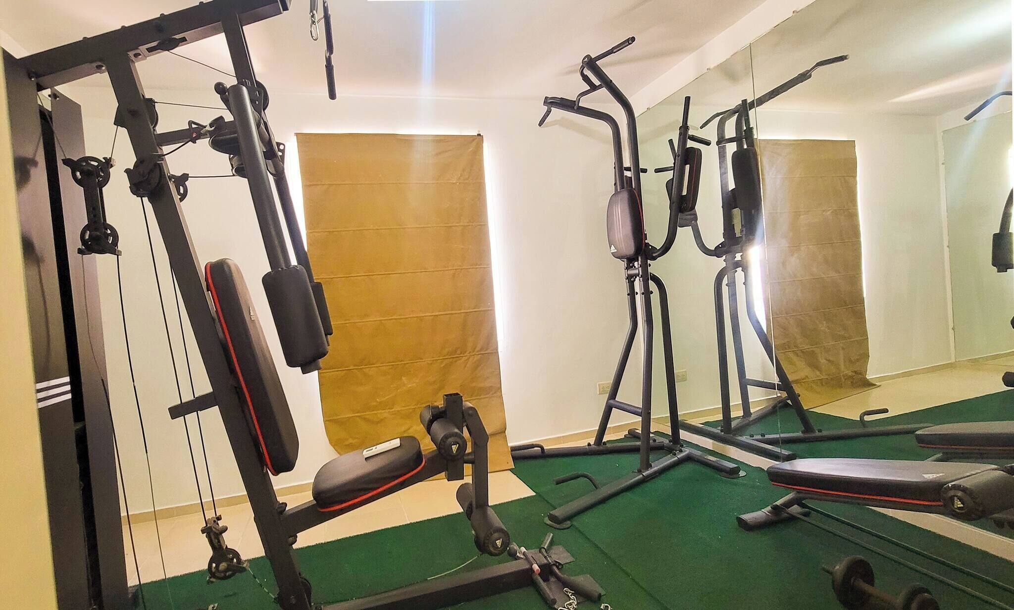 A gym with various exercise equipment, including weight machines and treadmills.
