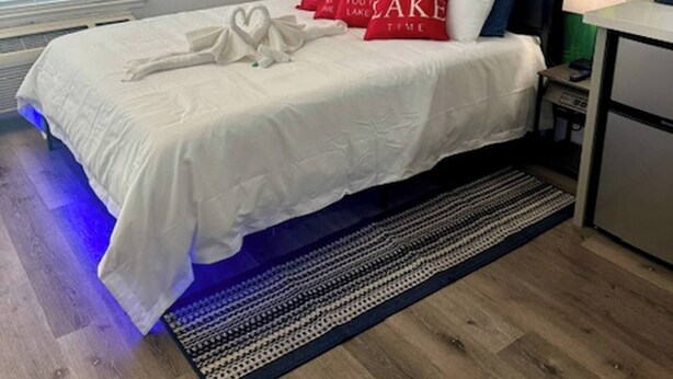 A bedroom with a bed, a mountain mural, a desk, and a chair. - Near Airport, Hospital, MidTown, 58” TV - Apt 254 (Reno)