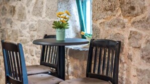 Un intérieur avec un mur en pierre, une table ronde et deux chaises.