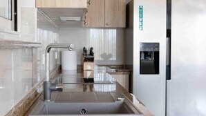 A modern kitchen with a stainless steel sink, wooden cabinets, and a built-in water dispenser.