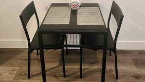 Ein Essbereich mit Tisch und Stühlen, einer Tischmatte und einer Fruchtschale.