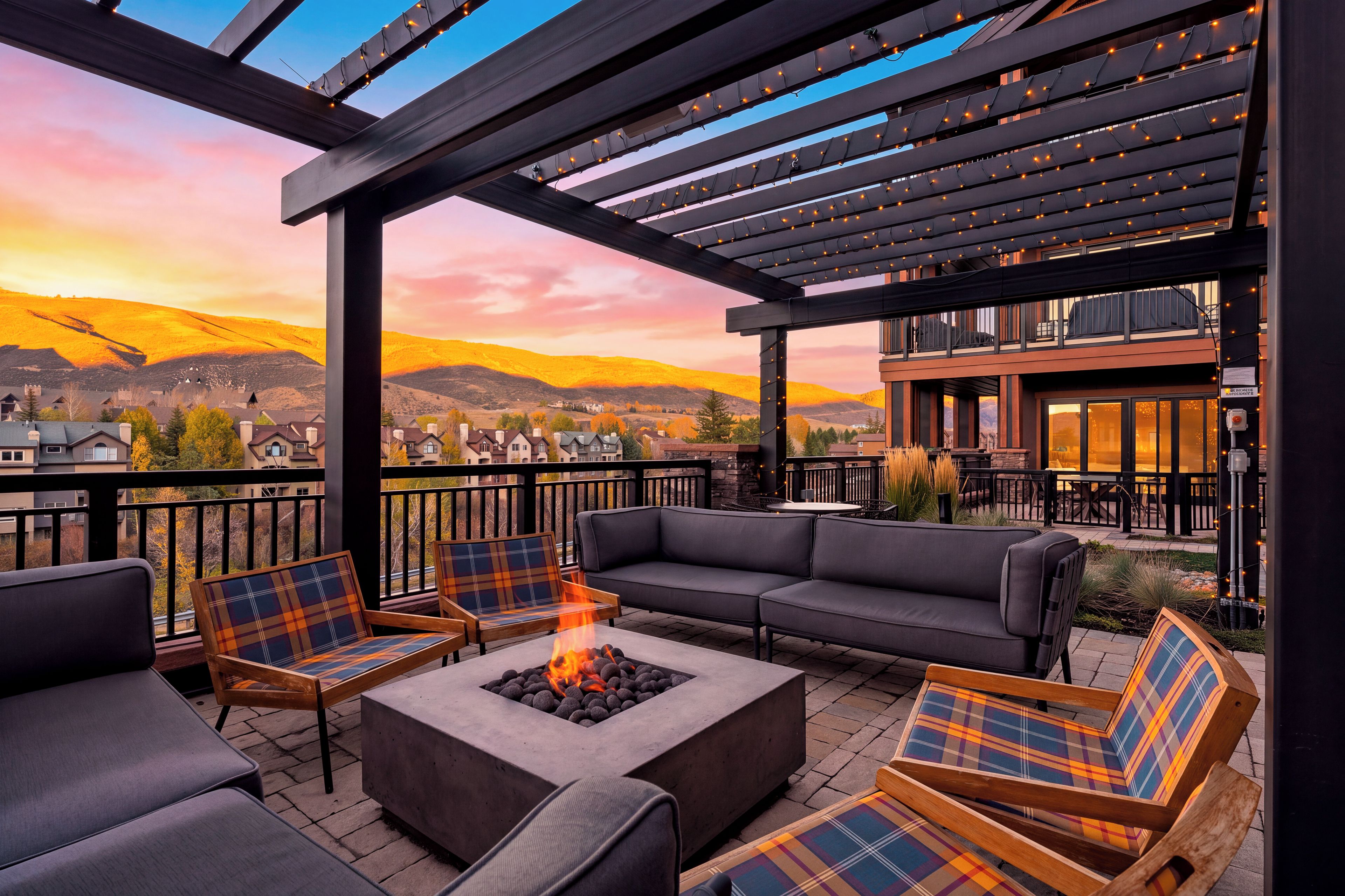 An outdoor patio with a fire pit, seating, and a view of the mountains.