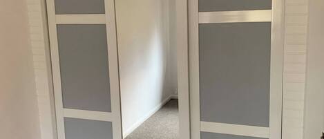 A room with a sliding door leading to a hallway.