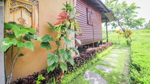 A house with a traditional door, a porch, and a garden with stepping stones. - Ubud Nature Escape Bungalow ricefield view (Kecamatan Ubud)