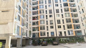 En flervåningsbyggnad med bostäder, balkonger, en parkeringsplats och en grind vid ingången.